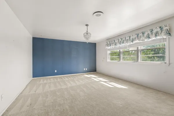 an empty room with chandelier fan