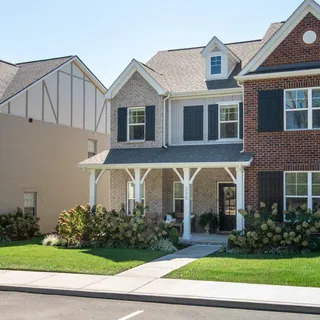 a front view of a house with a yard and plants