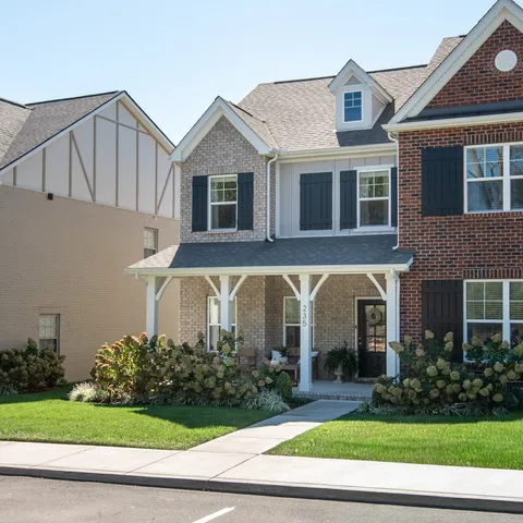 a front view of a house with a yard and plants