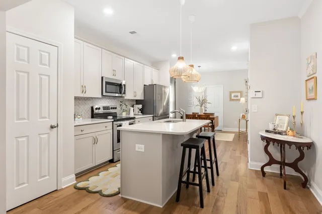 a kitchen with kitchen island granite countertop wooden floors and white appliances
