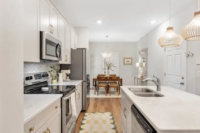 a kitchen with granite countertop a sink stove and refrigerator