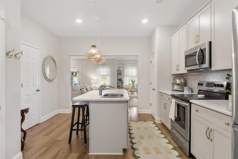 a kitchen with stainless steel appliances granite countertop a sink a stove and a refrigerator