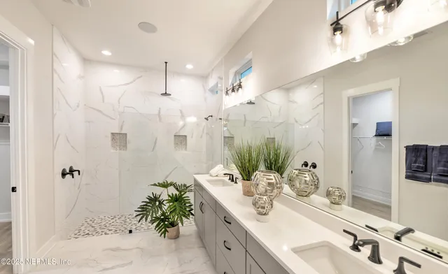 a bathroom with a double vanity sink mirror and shower