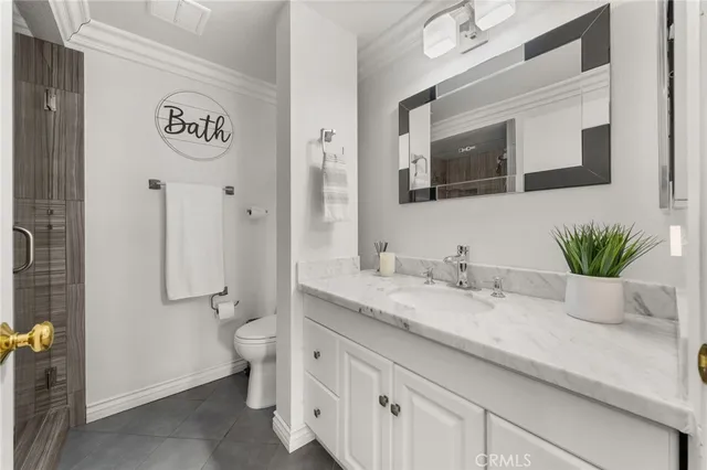 a bathroom with a granite countertop sink a toilet and mirror