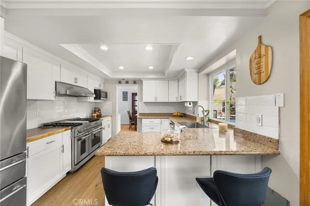 a large kitchen with stainless steel appliances granite countertop a lot of counter space and a sink