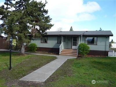 a front view of a house with a garden and yard