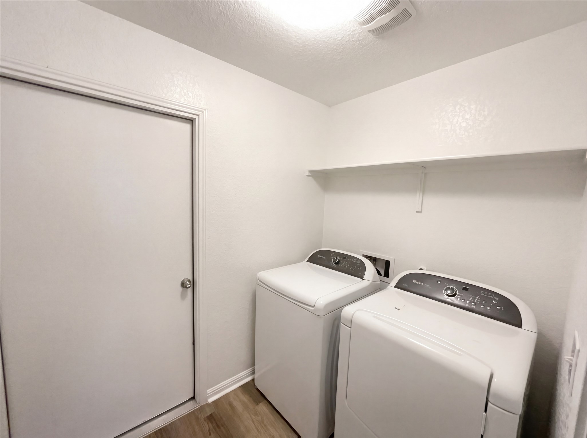 413 Dubina Avenue Georgetown, TX 78626 - Photo 16 of 22 Laundry room with wood finished floors, washing machine and dryer, and a textured ceiling