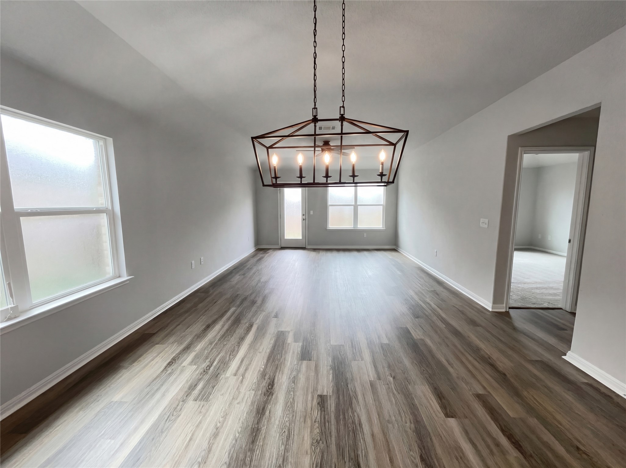413 Dubina Avenue Georgetown, TX 78626 - Photo 18 of 22 Unfurnished dining area with dark wood finished floors, lofted ceiling, and suspended lighting