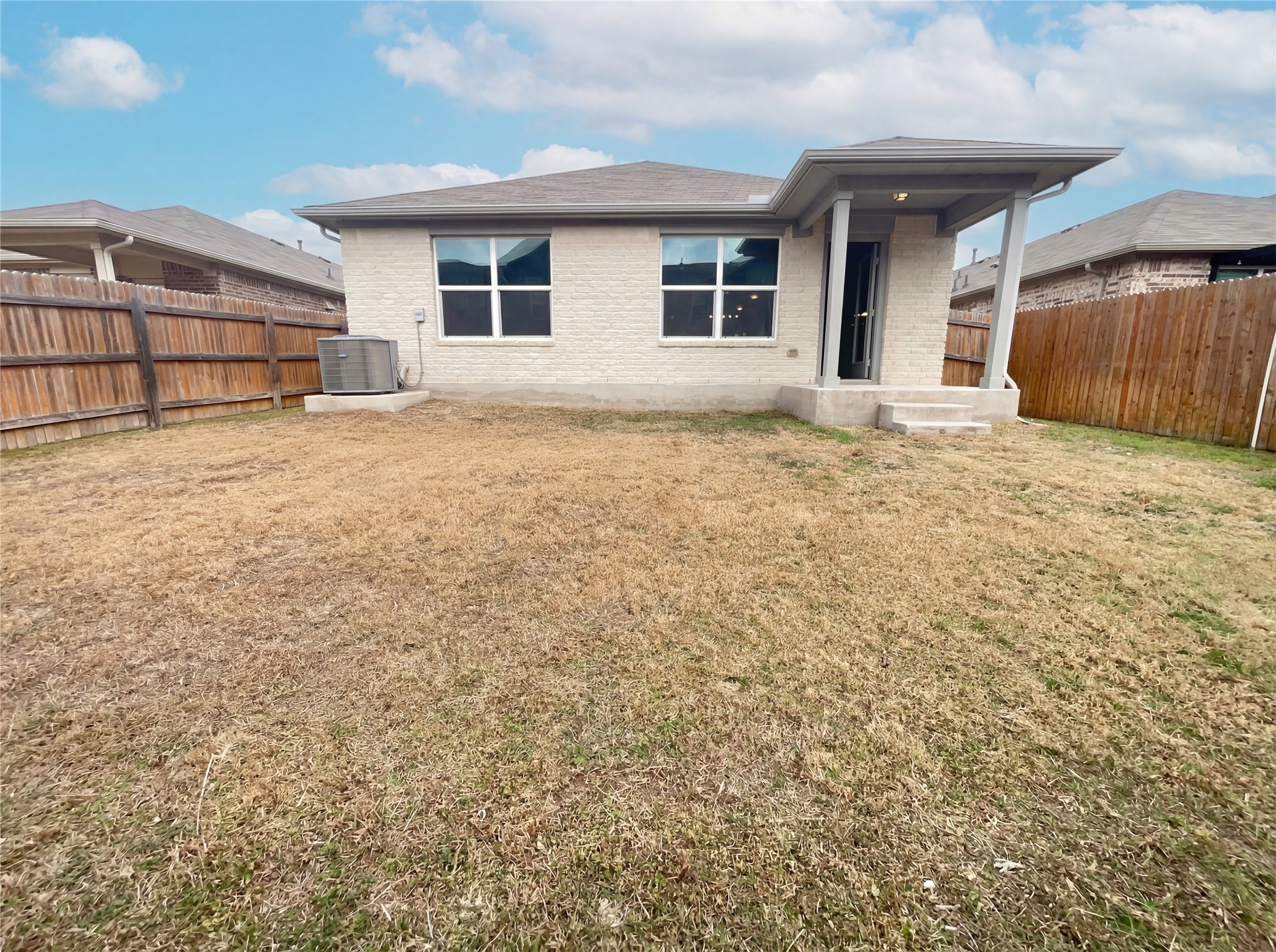413 Dubina Avenue Georgetown, TX 78626 - Photo 5 of 22 Rear view of house with brick siding and a fenced backyard