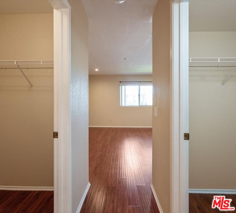 15114 Sherman Way, Unit 104 Van Nuys, CA 91405 - Photo 11 of 19 a view of an empty room with wooden floor and a window