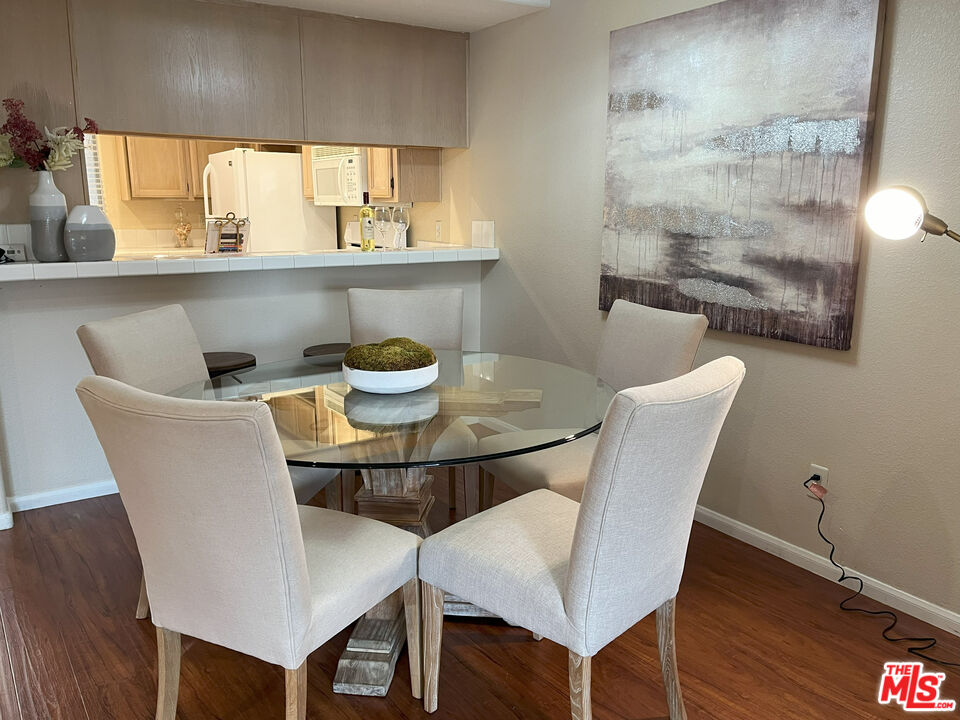 15114 Sherman Way, Unit 104 Van Nuys, CA 91405 - Photo 4 of 19 a view of a dining room with furniture and wooden floor