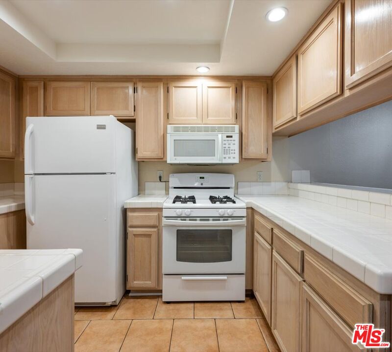 15114 Sherman Way, Unit 104 Van Nuys, CA 91405 - Photo 7 of 19 a kitchen with a stove top oven and refrigerator