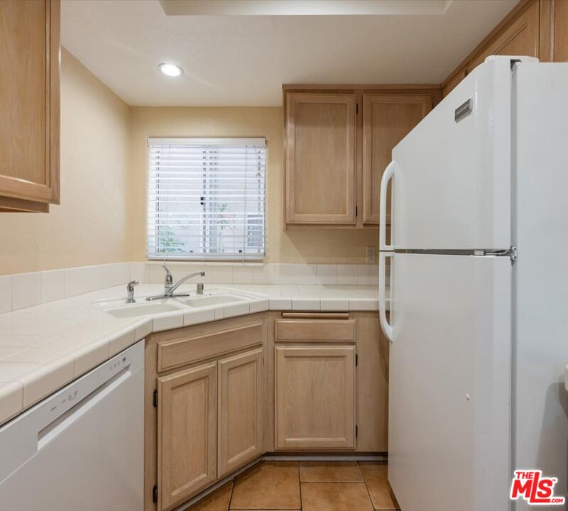 15114 Sherman Way, Unit 104 Van Nuys, CA 91405 - Photo 8 of 19 a kitchen with a sink a refrigerator and window