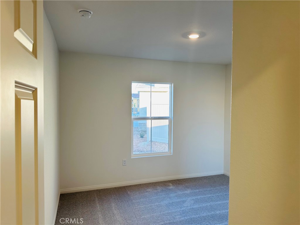 916 Runaway Trail San Jacinto, CA 92582 - Photo 14 of 23 a view of an empty room with wooden floor and a window