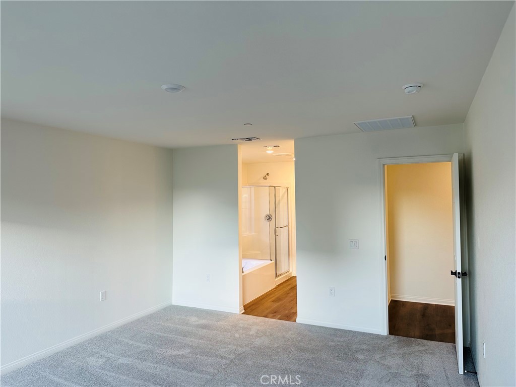 916 Runaway Trail San Jacinto, CA 92582 - Photo 16 of 23 an empty room with wooden door and mirror