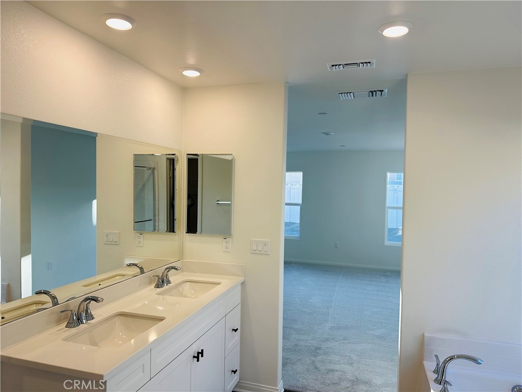 916 Runaway Trail San Jacinto, CA 92582 - Photo 20 of 23 a bathroom with a double vanity sink mirror and shower
