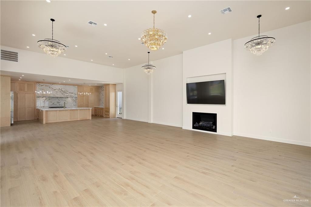 1215 Chelsea Drive Palmhurst, TX 78573 - Photo 11 of 30 a view of an empty room with a fireplace and a chandelier fan