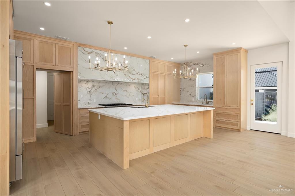 1215 Chelsea Drive Palmhurst, TX 78573 - Photo 13 of 30 a large kitchen with stainless steel appliances a large counter top a refrigerator and cabinets