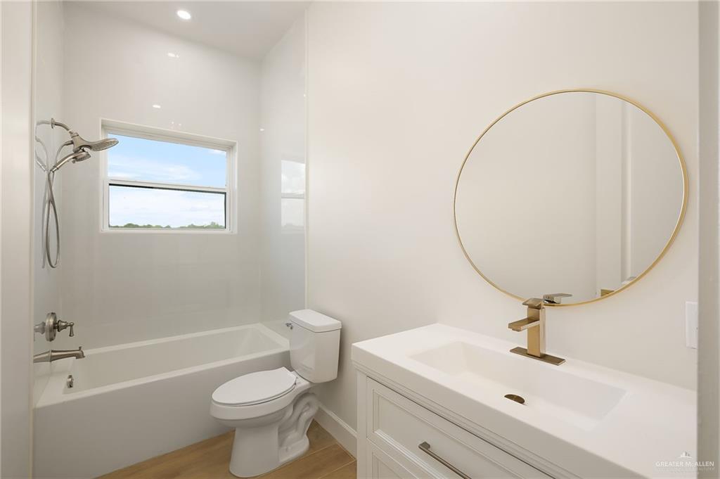 1215 Chelsea Drive Palmhurst, TX 78573 - Photo 18 of 30 a bathroom with a sink a toilet and a mirror