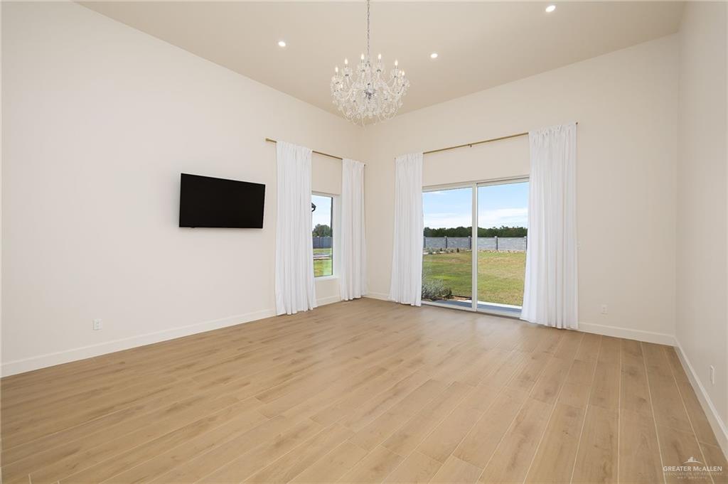 1215 Chelsea Drive Palmhurst, TX 78573 - Photo 21 of 30 a view of an empty room with a window and a kitchen
