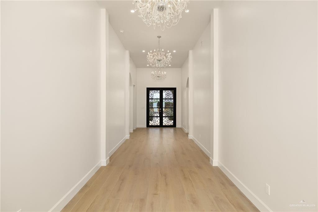 1215 Chelsea Drive Palmhurst, TX 78573 - Photo 6 of 30 a view of a hallway with wooden floor and a chandelier