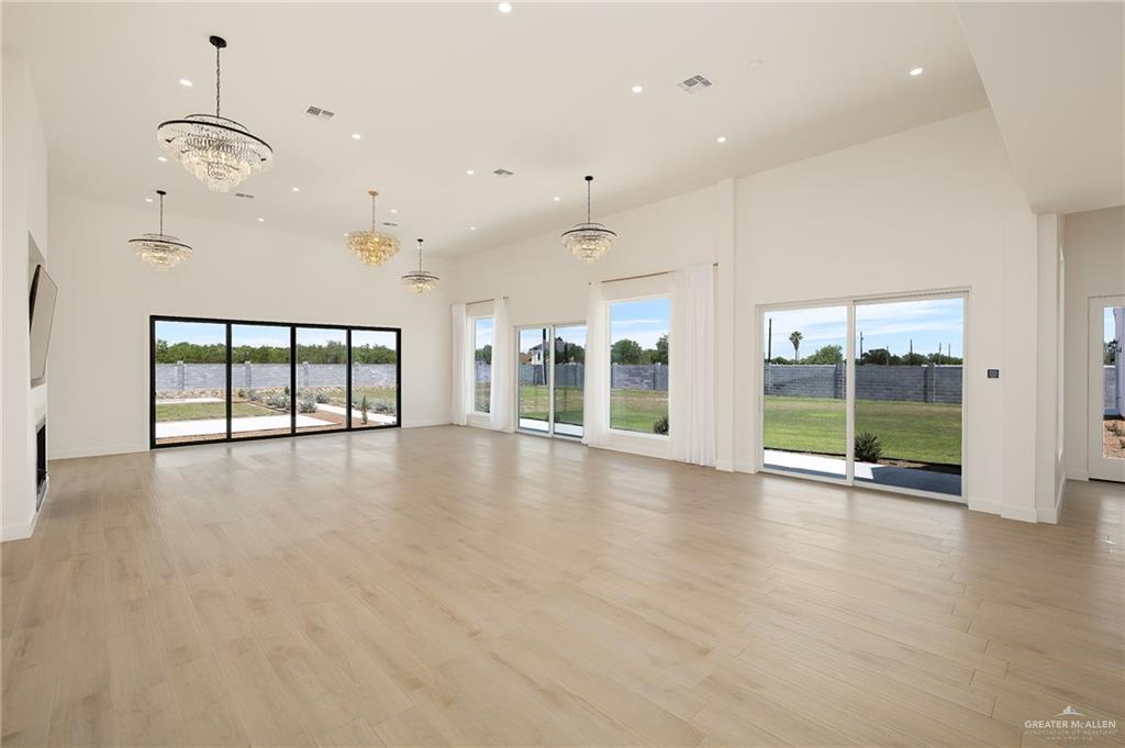 1215 Chelsea Drive Palmhurst, TX 78573 - Photo 7 of 30 an empty room with wooden floor and windows