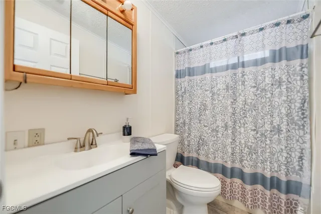 an empty room with wooden floor ceiling fan and windows