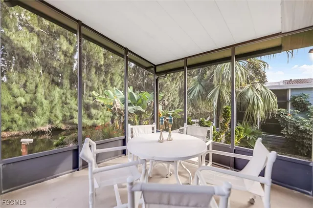 a dining room with furniture a chandelier and glass windows