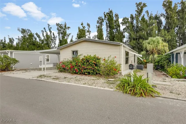 front view of a house with potted plants and a yard