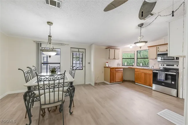 a kitchen with stainless steel appliances kitchen island granite countertop a table chairs and a stove