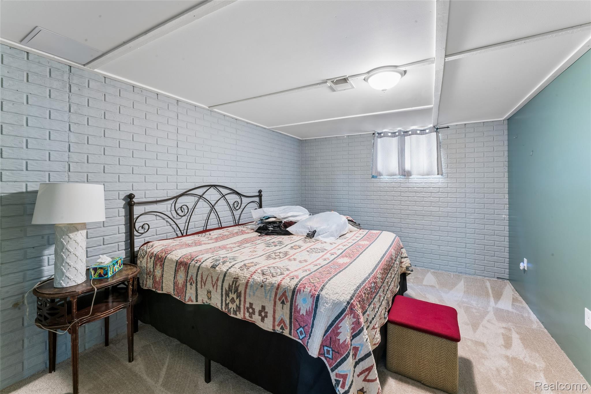 1336 West Hurd Road Clio, MI 48420 - Photo 32 of 43 Basement Bedroom featuring light gray brick-patterned walls, a contrasting green accent wall, and a white drop ceiling