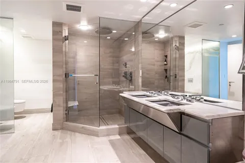 a bathroom with a granite countertop sink a mirror and a shower