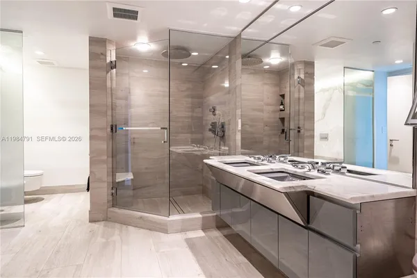 a bathroom with a granite countertop sink a mirror and a shower