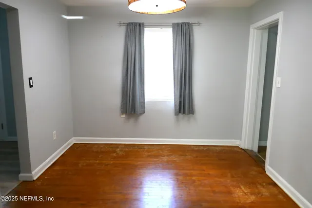 a view of room with window and wooden floor