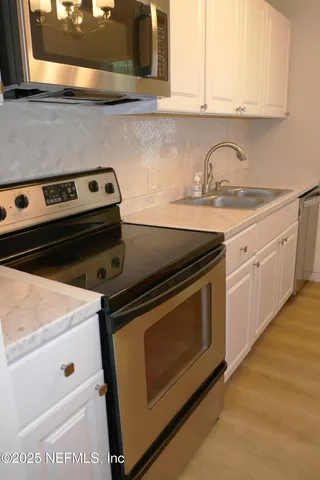 a stove top oven sitting inside of a kitchen