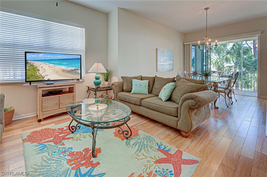 604 Ravinia Circle, Unit 604 Venice, FL 34292 - Photo 13 of 37 a living room with furniture a flat screen tv and a large window