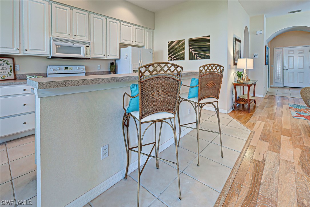 604 Ravinia Circle, Unit 604 Venice, FL 34292 - Photo 19 of 37 a kitchen with stainless steel appliances granite countertop a stove a sink and a refrigerator