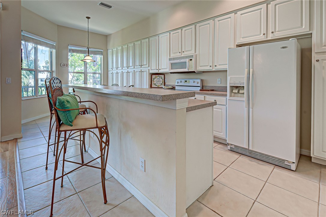 604 Ravinia Circle, Unit 604 Venice, FL 34292 - Photo 20 of 37 a kitchen with stainless steel appliances a refrigerator sink and cabinets