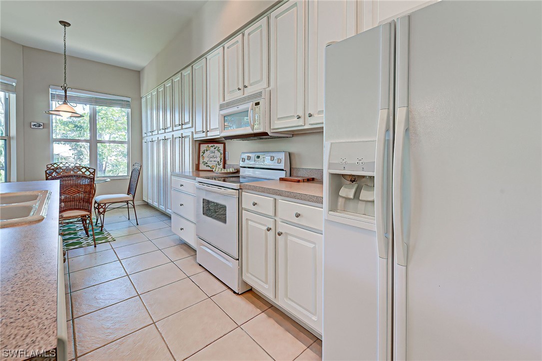 604 Ravinia Circle, Unit 604 Venice, FL 34292 - Photo 21 of 37 a kitchen with stainless steel appliances granite countertop a refrigerator and a stove