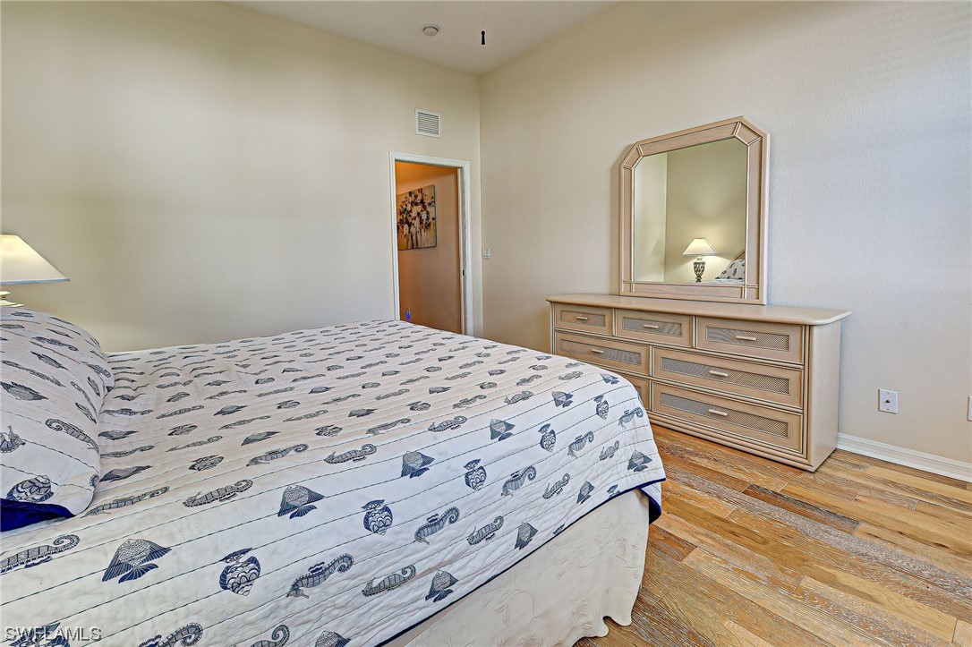 604 Ravinia Circle, Unit 604 Venice, FL 34292 - Photo 27 of 37 a bedroom with a bed and a mirror