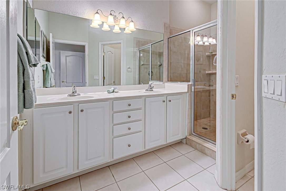 604 Ravinia Circle, Unit 604 Venice, FL 34292 - Photo 30 of 37 a spacious bathroom with a double vanity sink a mirror a vanity and a shower