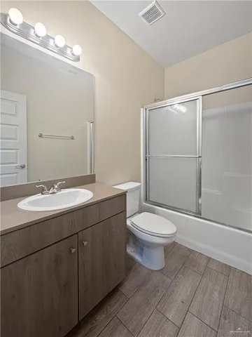a bathroom with a toilet a sink and mirror