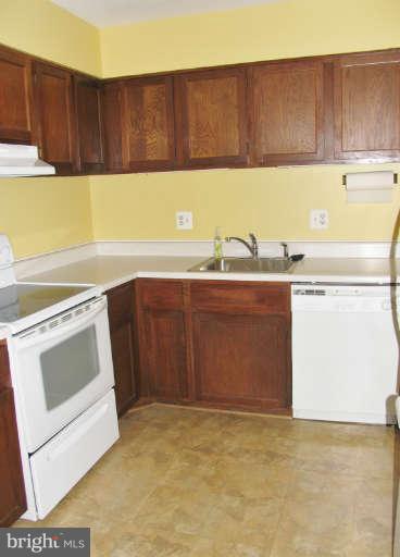 6137 Edsall Road, Unit J Alexandria, VA 22304 - Photo 5 of 13 a kitchen with a sink a stove and cabinets
