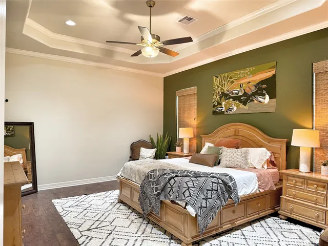 a bedroom with a large bed and a chandelier