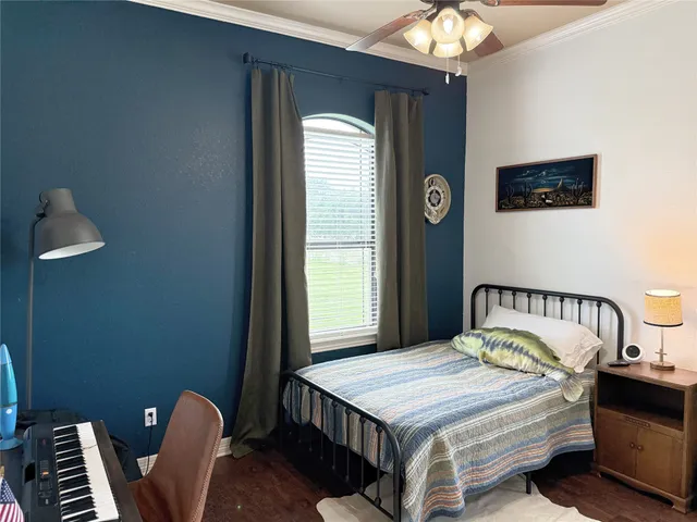 a bedroom with a bed next to a window with a chandelier