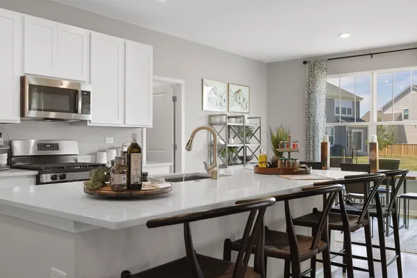 a kitchen with a dining table chairs and cabinets