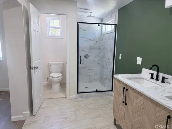 a bathroom with a sink a toilet and shower