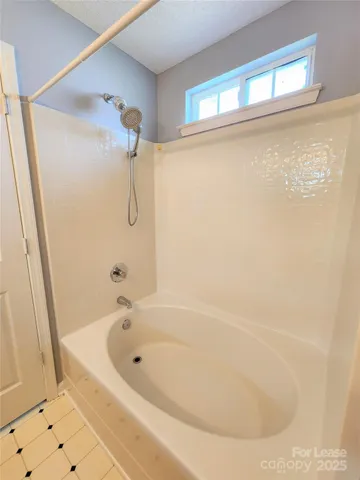 a white bath tub sitting next to a shower