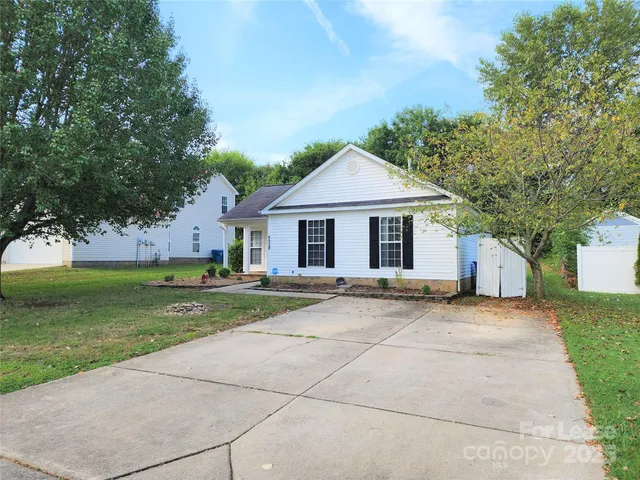 a front view of a house with a garden and yard