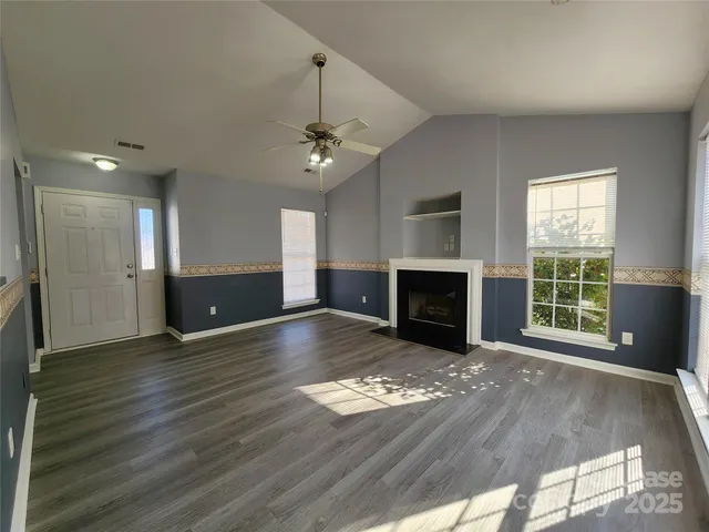 a view of empty room with wooden floor and fireplace